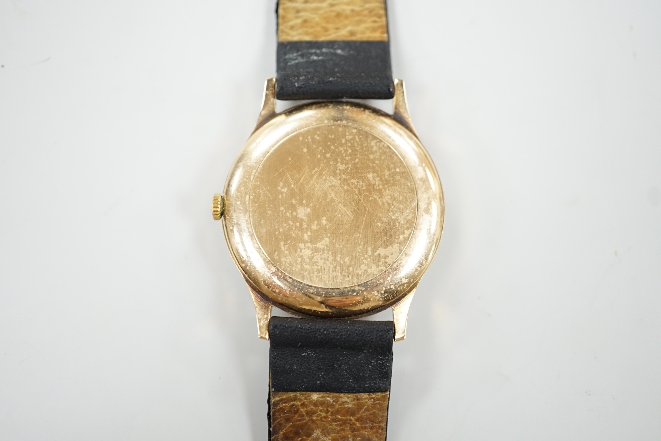 A gentleman's yellow metal quartz dress wrist watch, retailed by Mappin & Webb, with date aperture, case diameter 34mm, on a leather strap.